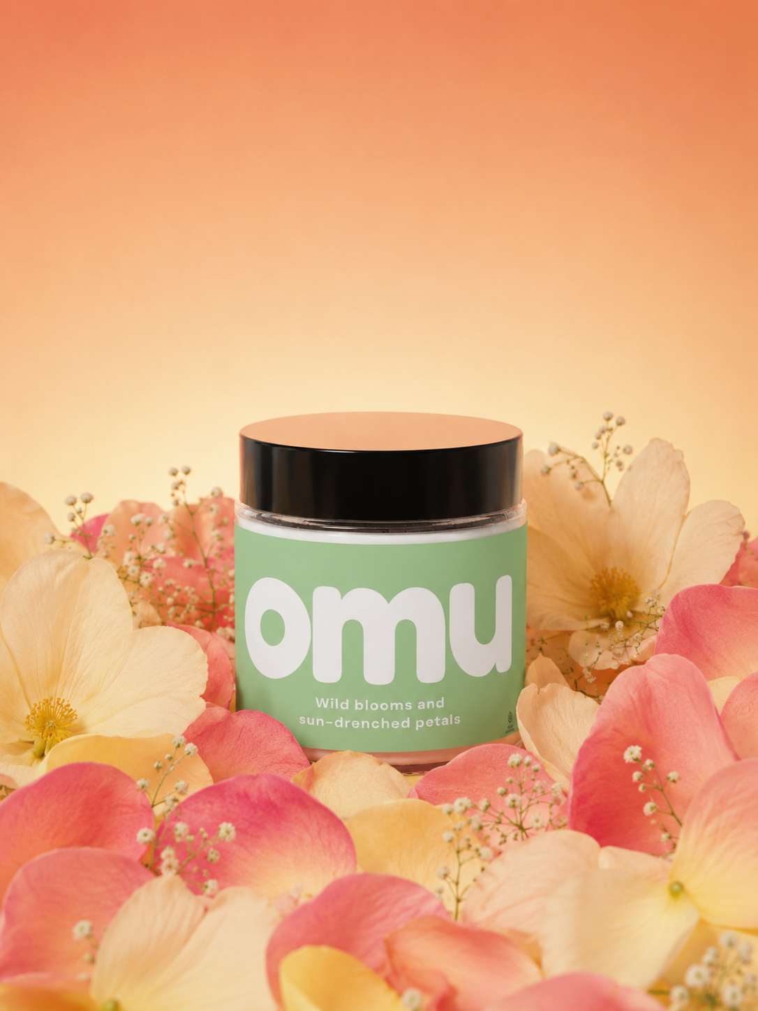 A luxury soy wax candle jar labeled omu surrounded by orange petals and pink flowers.